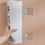 Estante vertical blanco para guardar ropa interior, montado en pared de madera con ganchos.