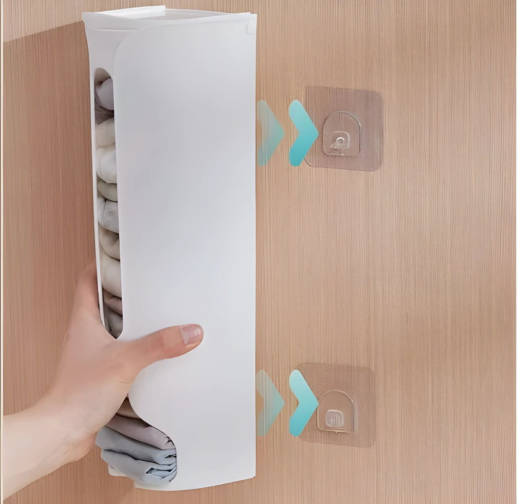 Estante vertical blanco para guardar ropa interior, montado en pared de madera con ganchos.