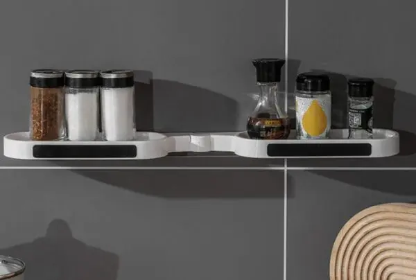 Estante de almacenamiento giratorio para baño, con frascos de condimentos en pared gris.