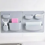 Estante de pared de pasta gris para cocina con pelador, esponja rosa y esponja de malla.