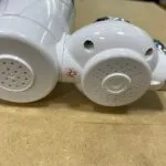 Filtro purificador de agua para grifo, con dos salidas redondas y número 32 en naranja.