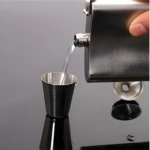 Licorera Whizkera 9 OZ Jack Daniels, vertiendo licor en copa con embudo.