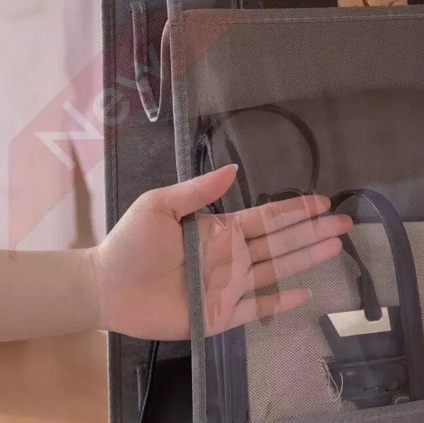 Mano revisando organizador de bolsos de 4 niveles en armario gris.