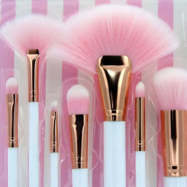 Brochas de maquillaje Ruby Face Brush Kit con cerdas rosas y mangos blancos, ideales para aplicación profesional.
