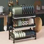 Platero escurridor de loza de 3 niveles con utensilios y adornos de cocina en la encimera.