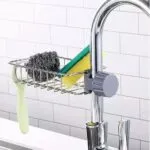 Soporte metálico para esponjas y jabón en grifo de cocina, diseño moderno y práctico.