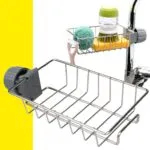 Estante metálico para grifo con esponja y dispensador de jabón.