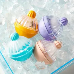 Set x4 moldes esféricos para hielo en silicona con forma de cupcake en varios colores sobre cubos de hielo.
