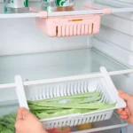 Organizador ajustable para nevera con judías verdes y latas en estantes de refrigerador.