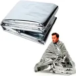 Manta térmica plateada para emergencias, compacta y esencial para temperaturas extremas.