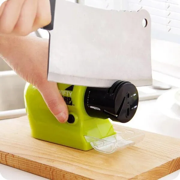 Afilador de cuchillos eléctrico portátil Nifty Sharp afila un cuchillo grande en tabla de madera.