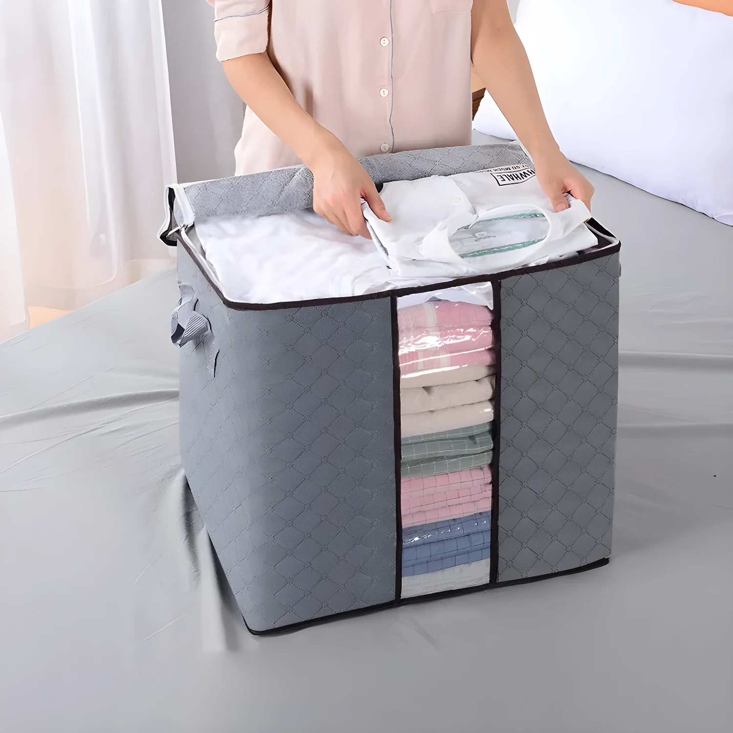 Bolsa plegable gris para closet con ventanas transparentes, ideal para organizar ropa.