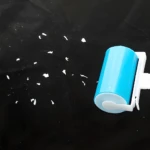 Set x2 rodillo limpiador de pelusa lavable y reutilizable en acción sobre superficie oscura con residuos.