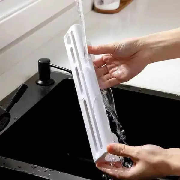Soporte para cuchillos blanco siendo enjuagado bajo el grifo en un fregadero negro.