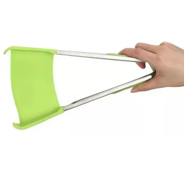 Pinza espátula verde con mangos metálicos, sujetada por una mano.