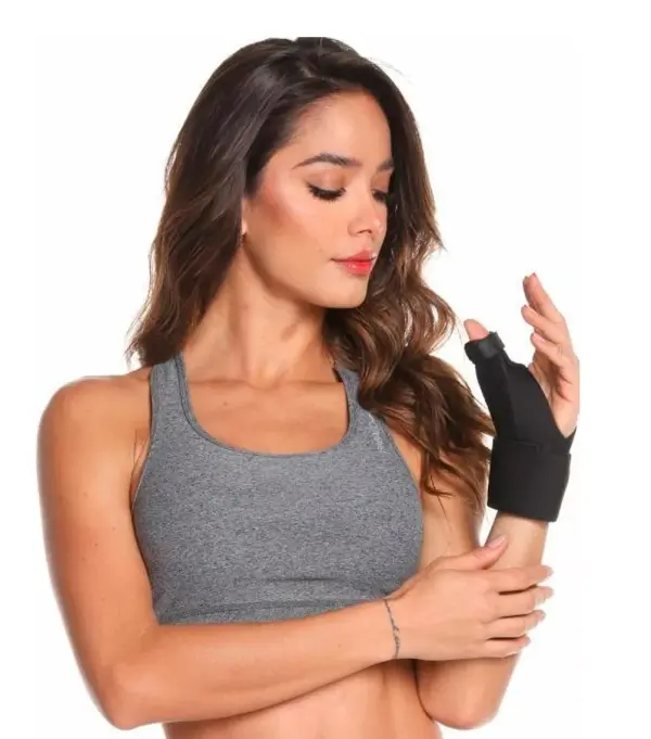Inmovilizador ortopédico de pulgar ajustable para mujer con soporte negro y top deportivo gris.