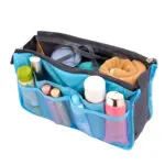 Organizador expandible para bolsos y maletas de dama de viaje con compartimentos, cremallera y toalla enrollada.