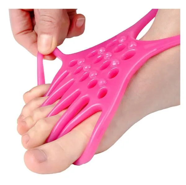 Banda elástica rosa para ejercitar y separar los dedos de los pies, vista cercana.