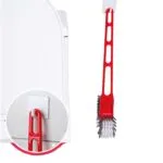 Cepillo doble 360 para baño, diseño moderno colgado en gancho blanco sobre superficie texturizada.