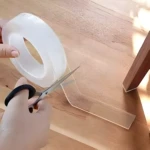 Cinta doble faz de silicona transparente para pegar objetos en superficies de madera.