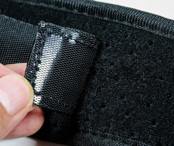 Corrector de postura con cierre de velcro plateado y material negro transpirable.