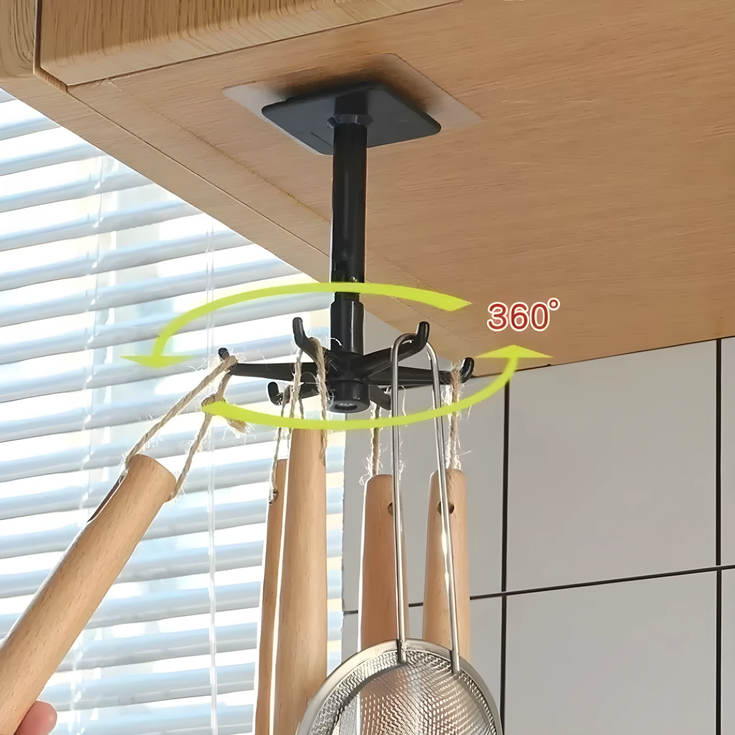 Gancho giratorio adhesivo para cocina con utensilios de madera colgando.
