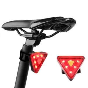 Linterna trasera triangular roja para bicicleta, montada en poste de asiento, con otra en primer plano.