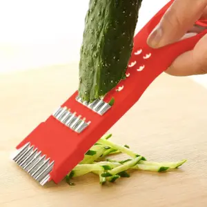 Rebanador de verduras 5 en 1 de acero inoxidable rebanando pepino sobre tabla de madera.