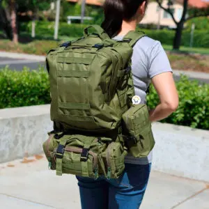 Morral militar verde de 56 litros, táctico para asalto y camping, en la espalda de una mujer.
