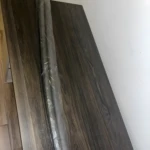 Set x2 protectores de goma para puerta enrollados y empacados sobre superficie de madera oscura.