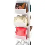 Porta bolsos colgante blanco con 4 compartimentos, exhibe bolsos de diferentes estilos y colores.