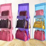Colgador de bolsos en tres colores: rosa, morado y azul, con múltiples compartimentos para organizar carteras.