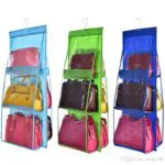 Porta bolsos colgante con 3 compartimentos transparentes y varios bolsos de mano de colores.