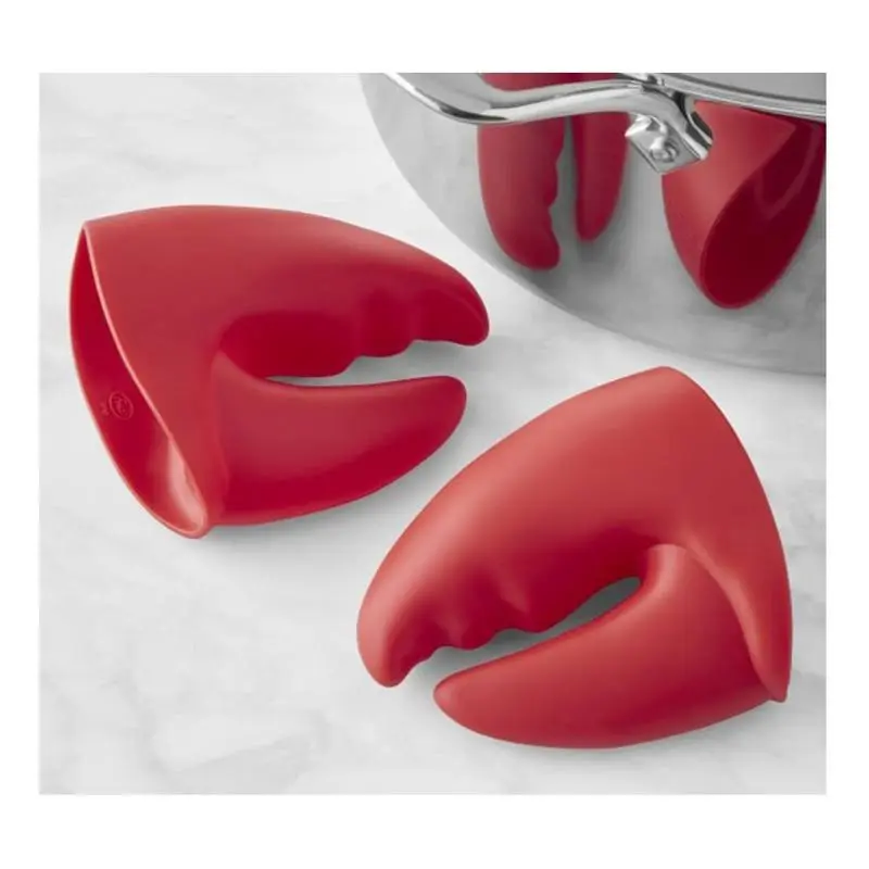 Guantes antiquemaduras de silicona roja con forma de pinza de langosta, usados en una olla.