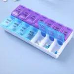 Pastillero semanal con divisiones para día y noche, organizado con pastillas y cápsulas.