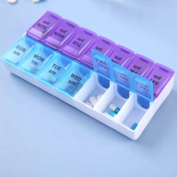 Pastillero semanal con divisiones para día y noche, organizado con pastillas y cápsulas.