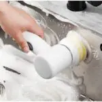 Cepillo eléctrico giratorio Magic Brush 5 en 1 limpiando a mano un lavaplatos con espuma.