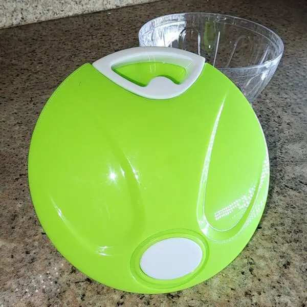 Picatodo picador de alimentos manual verde brillante con manija blanca y tazón transparente.