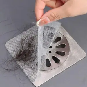 Malla desechable para drenaje con cabello atrapado, vista de cerca del accesorio de baño.
