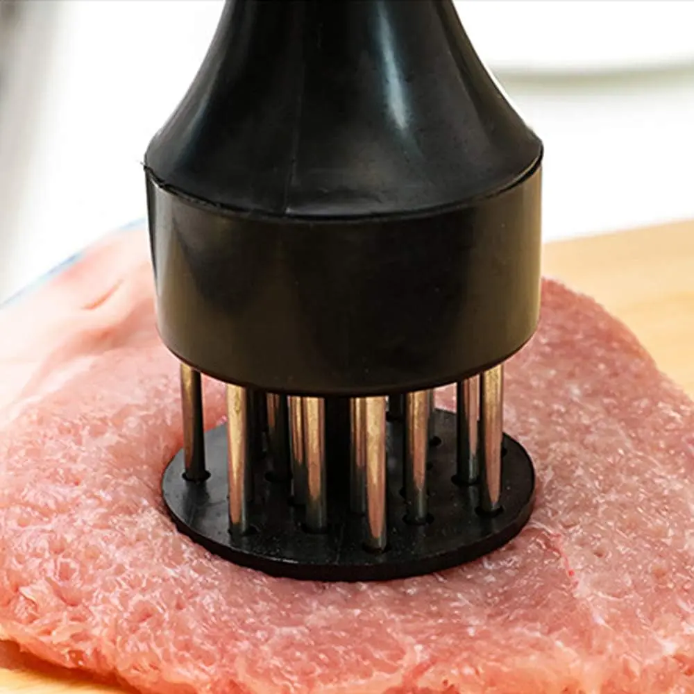 Ablandador de carne con pin de acero inoxidable tenderizando un corte de cerdo.