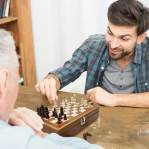 Joven juega ajedrez con set de licorera Jack Daniel's dorado en cofre.
