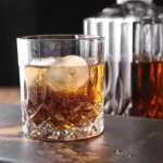 Molde Calavera Hielera Drop: vaso de whisky con hielo con forma de calavera y licor ámbar.