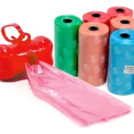 Dispensador de bolsas en forma de hueso rojo con 4 rollos de bolsas para mascotas en colores surtidos.