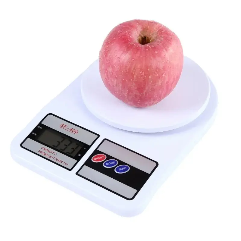 Gramera digital SF-400 con manzana roja. Mide 333 gramos en una báscula blanca.