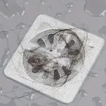 Set x100 mallas desechables para drenaje con pelo acumulado, tapando el desagüe en un baño.