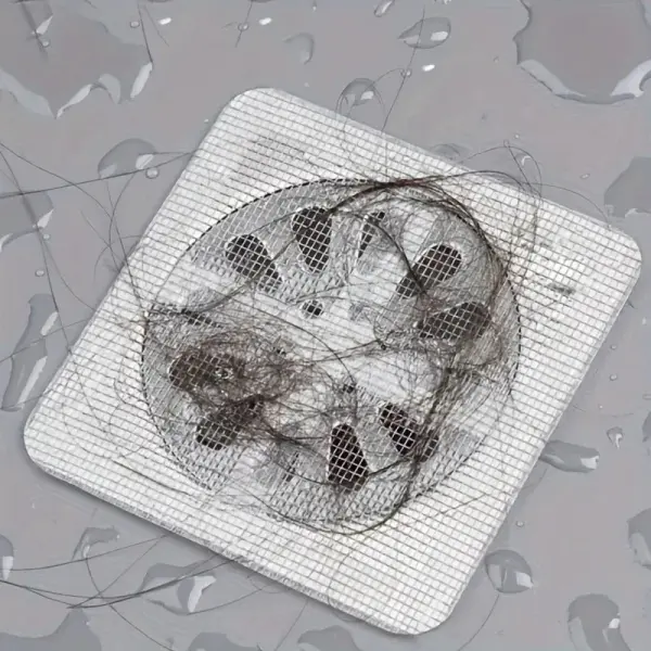 Set x100 mallas desechables para drenaje con pelo acumulado, tapando el desagüe en un baño.