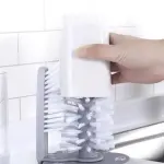 Cepillo limpiador de vasos blanco insertado en cepillo doble giratorio para limpieza profunda.