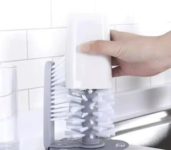 Cepillo limpiador de vasos blanco insertado en cepillo doble giratorio para limpieza profunda.