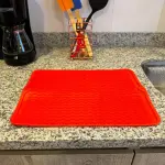 Alfombra de silicona roja multiusos para secar platos y proteger superficies de cocina.