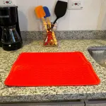Tapete de silicona multiusos rojo para cocina gourmet, ideal para secar platos y proteger superficies.